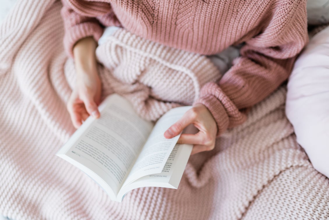 Women reading a book in bed